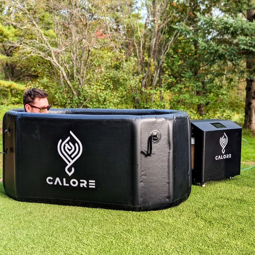 A man sitting in a black cooler on top of a lush green field.