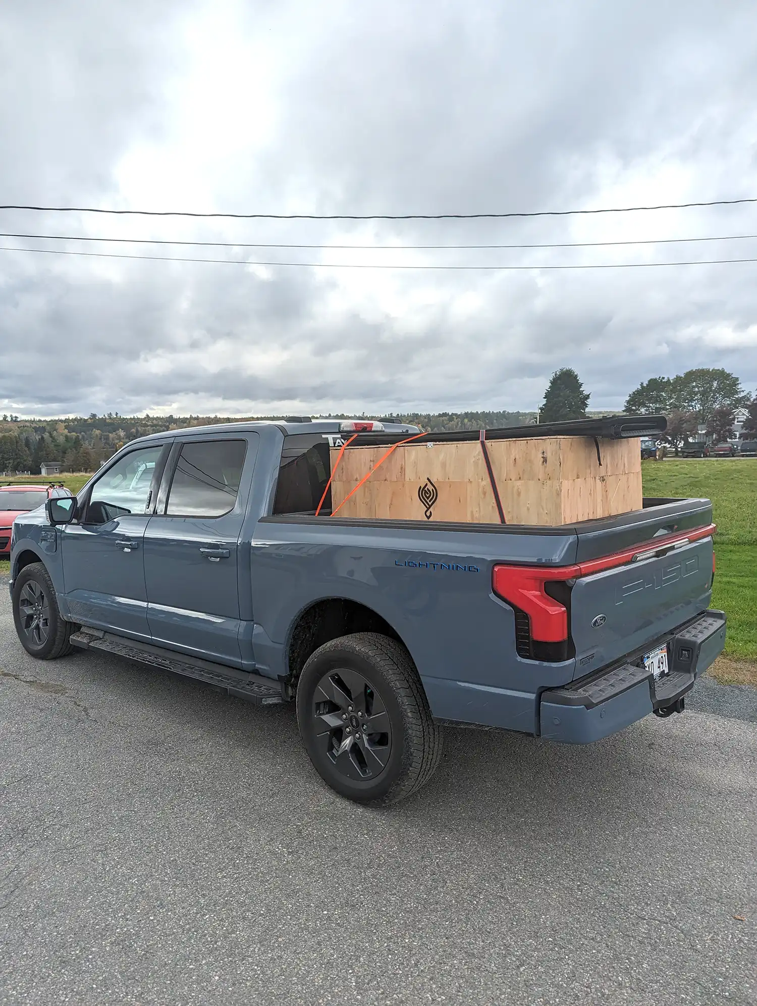 A pickup truck with a wooden crate in the back.